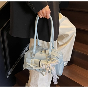 Detail of light blue patent leather bowling bag with lace bow and pearl charms