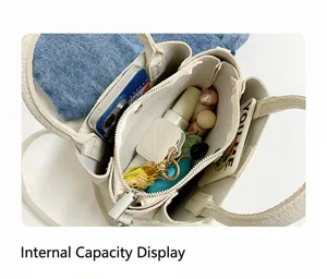 Top view of cream bucket bag interior showing three compartments with daily essentials