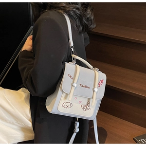 Detailaufnahme der Stickerei und des Mehrzweckgurts eines zweifarbigen Rucksacks