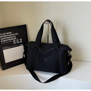 Detail of durable black travel bag with sturdy handles and adjustable crossbody strap