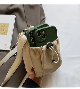 Detailansicht der geräumigen Innenseite dieser beigen Kordelzugtasche mit zwei Smartphones