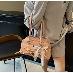 Pink glossy bowling bag featuring decorative pockets with bows and pearl lace charms