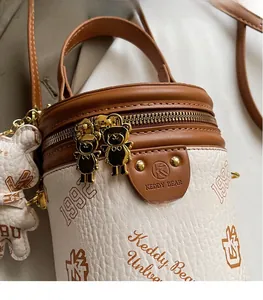 Close-up of Keddy Bear cylinder bag showing lychee texture and bear zipper detail