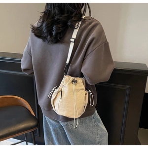 Beige Kordelzug-Beuteltasche mit schwarzen Netztaschen und Schulterriemen