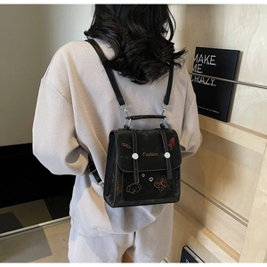 Detailansicht des schwarzen Mini-Rucksacks mit modischen Stickereien und Schnallenriemen
