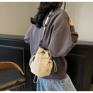Detail der beigen Beuteltasche mit strukturierter Plissee-Stoff und abnehmbarem Gurt