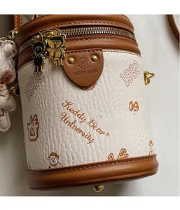 Detailed macro view of the cylinder bag showing the lychee texture and bear zipper head