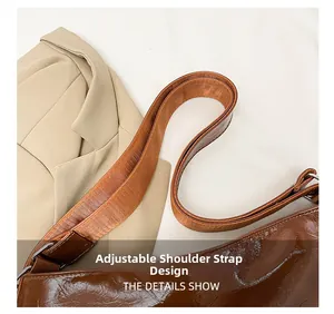 Dettaglio della tracolla larga regolabile con fibbia argento su borsa vintage marrone