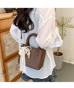 Borsa in pelle marrone con fiocco in pizzo bianco e ciondolo di perle eleganti