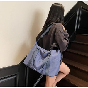 Detail of travel tote bag with adjustable strap and side pocket in fog blue nylon