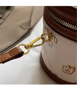 Close-up of golden metal hooks and premium zipper details on retro cylinder bucket bag