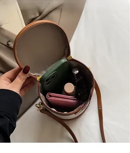 Internal view of the retro cylinder crossbody bag showing storage space for phone and wallet