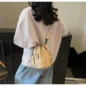 Detailansicht der khakifarbenen Beuteltasche mit Netzseitentasche an einem Modell