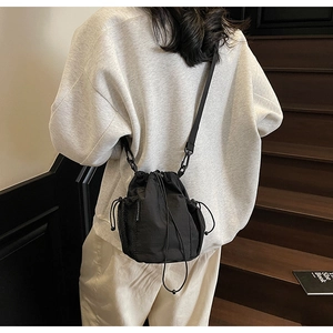 Detail einer minimalistischen schwarzen Nylon-Beuteltasche mit seitlicher Netztasche