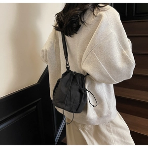 Rückansicht eines Modells mit schwarzer Nylon-Beuteltasche und verstellbarem Riemen