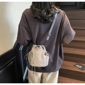 Detail der khakifarbenen Nylon-Beuteltasche mit seitlicher Netztasche und verstellbarem Gurt