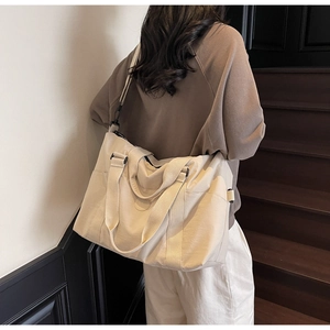 Detail of beige large capacity travel tote showing durable handles and side storage pocket