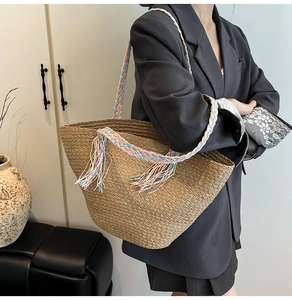 Dettaglio della borsa tote in paglia intrecciata con spalline colorate e frange vivaci