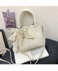 Detail of lychee pattern leather bag with pearl bow, lace trim and heart pendant