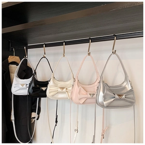 Row of colorful mini handbags with bows and metal logo displayed on hooks