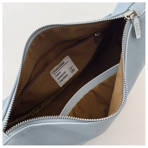 Detail view showing interior storage of light blue dumpling bag with zipper pocket