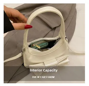 Top view of cream white shoulder bag interior showing daily storage capacity and bow detail