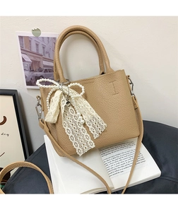 Dettaglio della borsa a secchiello kaki con elegante ciondolo a fiocco in perle e pizzo