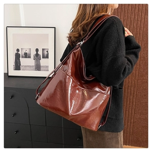 Dettaglio della borsa tote bordeaux in pelle verniciata lucida con trama screpolata