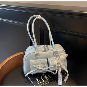 Detail of light blue glossy leather bowling bag with bow pockets and pearl charm