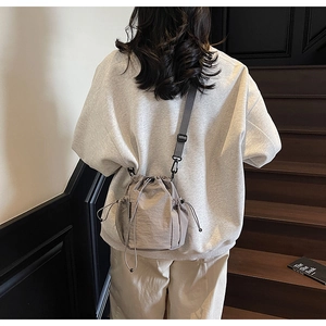 Details von verstellbarem Gurt und Kordelzugverschluss an einer Nylon-Eimertasche