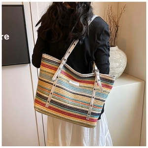 Detail of multi-color striped woven straw tote bag with silver adjustable shoulder straps