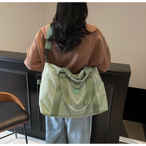 Light green travel tote bag shown on model back to demonstrate large capacity size