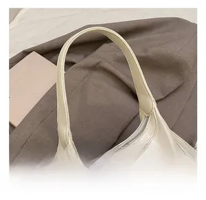 Close-up of cream white leather handbag with silver metallic triangle logo detail
