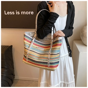 Detail of colorful woven straw tote with metallic silver trim and adjustable strap
