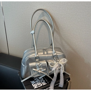 Detailed macro view of silver metallic handbag with twin bows and pearl lace charms