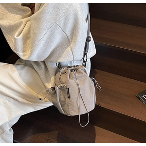 Detail der grauen Nylon-Beuteltasche mit Netztasche und Kordelzug an einem Modell