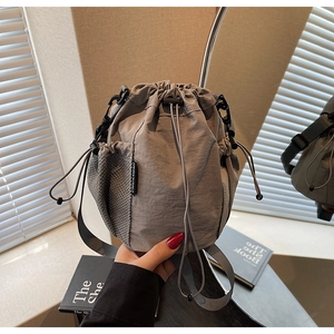 Detailansicht der grauen Nylon-Beuteltasche mit Netztasche und gewebtem Etikett