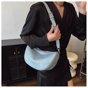 Detail shot of light blue crescent bag with stone texture and silver metal buckle