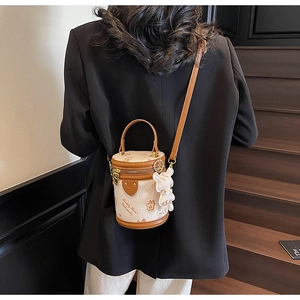 Detail of canvas cylinder bag with brown trim and Teddy Bear University print and charm