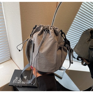 Details einer grauen Nylon-Beuteltasche mit Kordelzugverschluss und seitlicher Netztasche