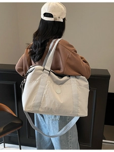 Large beige travel tote bag and crossbody fitness bag worn by model in casual style