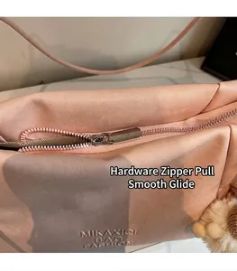 Detail of pink leather tote featuring silver metal zipper and embossed fashion logo