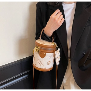 Detail of cylinder bucket bag with Teddy Bear University print and metal bear pendant