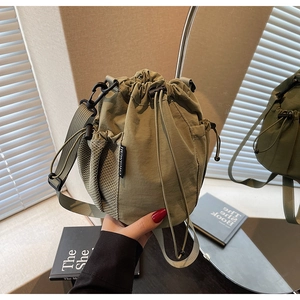 Detail der armee-grünen Beuteltasche mit Kordelzug, Seitentasche und Markenetikett