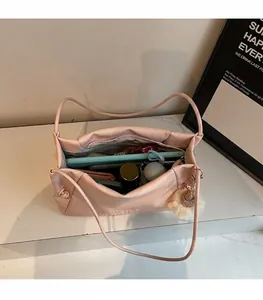 Top view of pink leather tote bag showing large interior space and plush charm