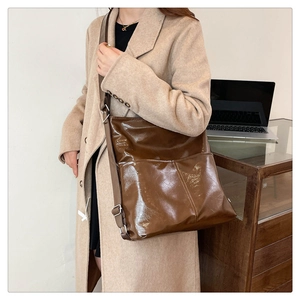 Dettaglio borsa shopper in pelle marrone lucida con tracolla regolabile