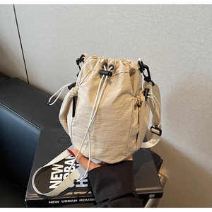 Detail der beigen Nylon-Beuteltasche mit seitlicher Netztasche und breitem Gurt