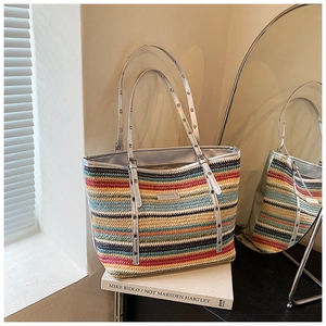 Detail of colorful striped woven tote bag with silver handles and metallic grommet eyelets