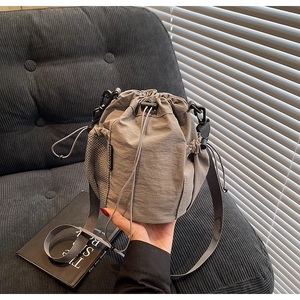 Detail der dunkelgrauen Nylon-Beuteltasche mit schwarzer Netzseitentasche und Kordelzug