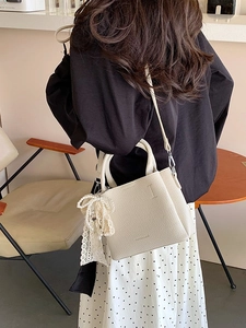 Borsa a secchiello beige in pelle con ciondolo di perle e tracolla moda